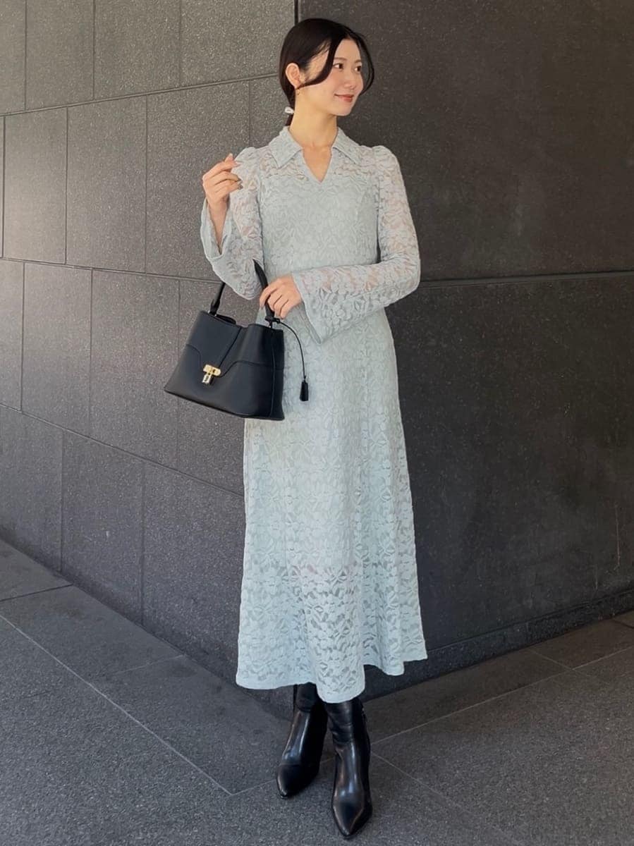 ブラック系のブーツ、グリーン系のワンピース、ブラック系のハンドバッグを着用したレディースの冬コーディネートの2枚目の写真