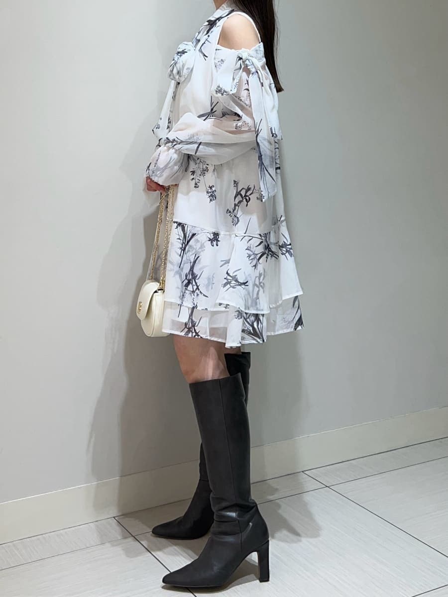 グレー系のブーツ、ホワイト系のワンピース、ホワイト系のショルダーバッグを着用したレディースの春コーディネートの3枚目の写真