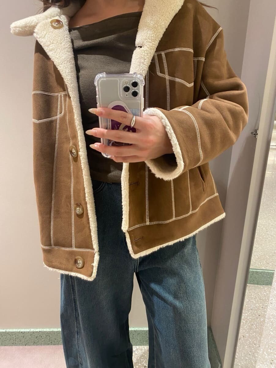 ブルー系のデニムパンツ、ブラウン系のニット/セーター、ブラック系のブーツを着用したレディースの秋コーディネートの6枚目の写真