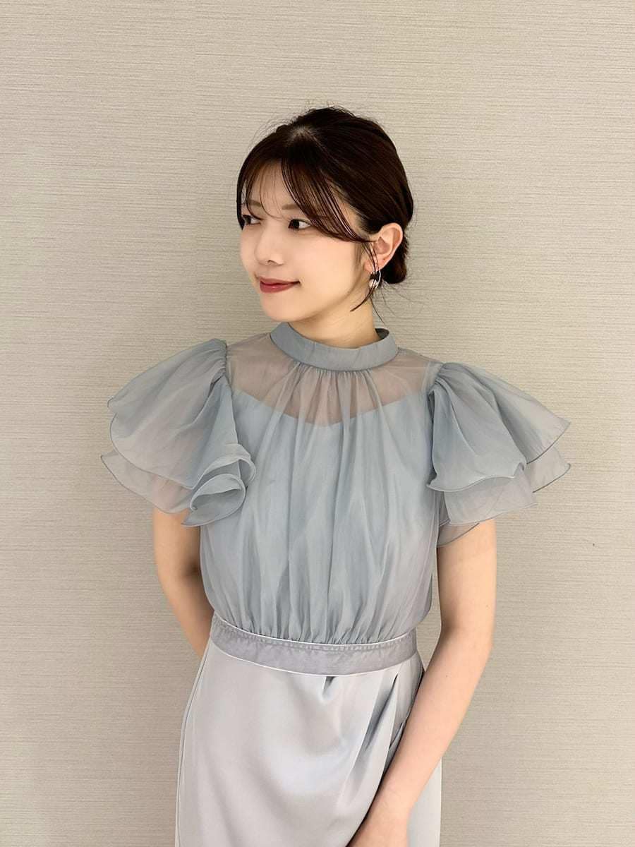 ブラウン系のハンドバッグ、ブルー系のワンピース、ブラウン系のパンプスを着用したレディースの秋コーディネートの5枚目の写真
