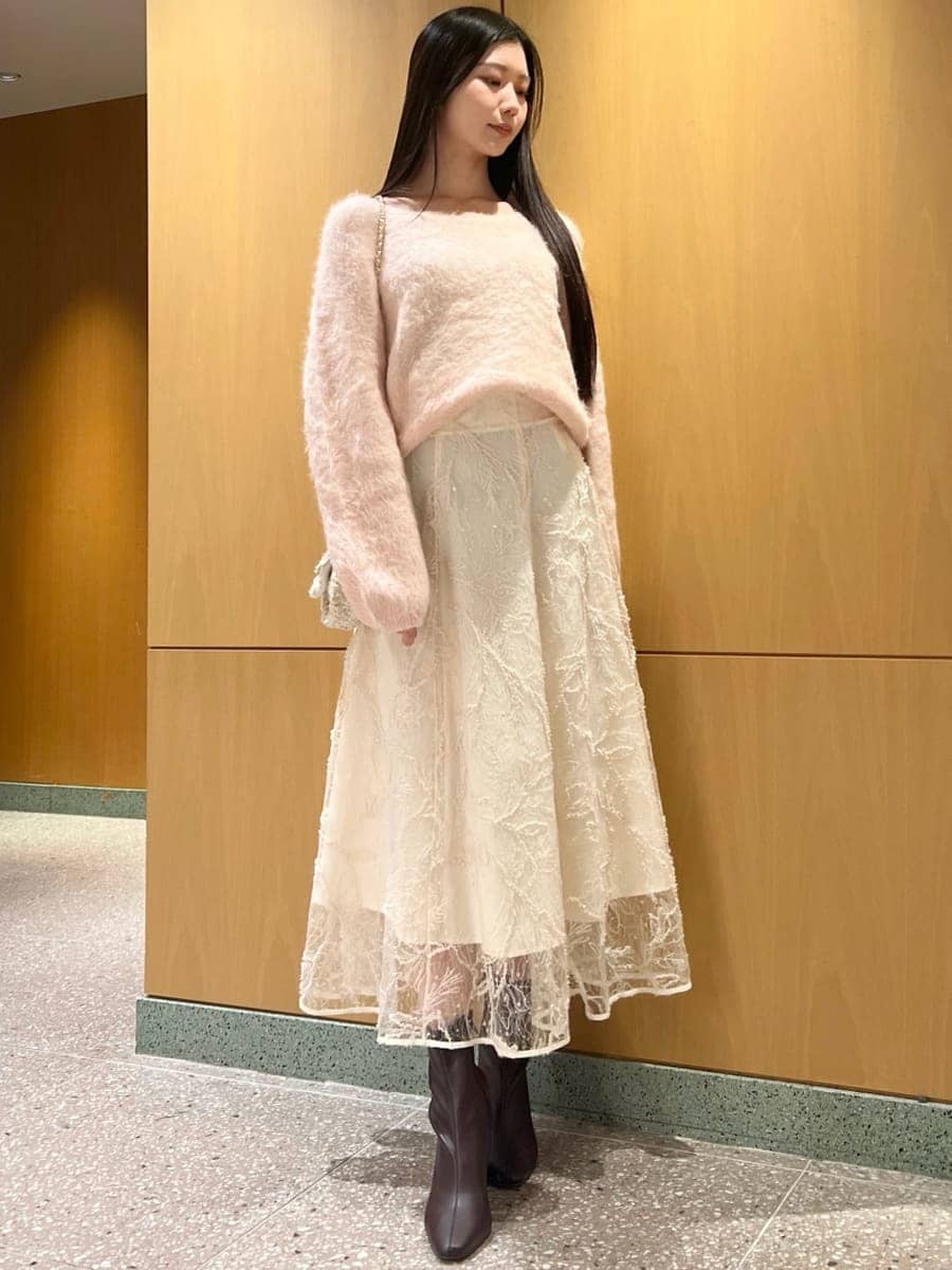 レッド系のブーツ、ホワイト系のショルダーバッグ、ピンク系のニット/セーターを着用したレディースの冬コーディネートの3枚目の写真