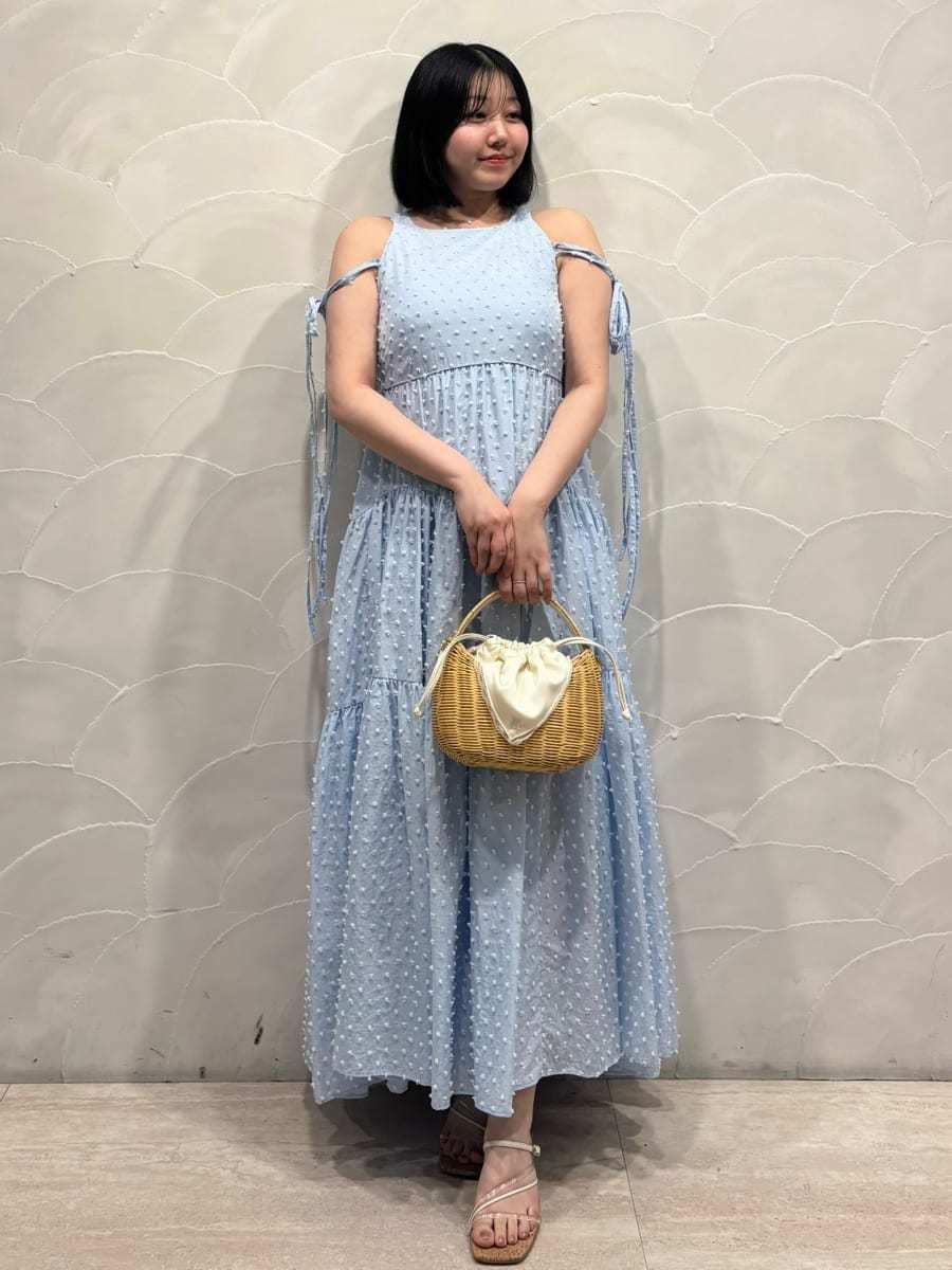 ホワイト系のかごバッグ、ブルー系のワンピース、ホワイト系のカーディガン/ボレロを着用したレディースの春コーディネートの5枚目の写真