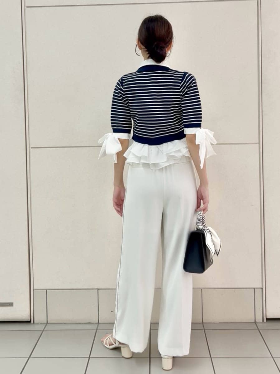 ブラック系のハンドバッグ、ホワイト系のその他パンツ、その他のニット/セーターを着用したレディースの夏コーディネートの4枚目の写真