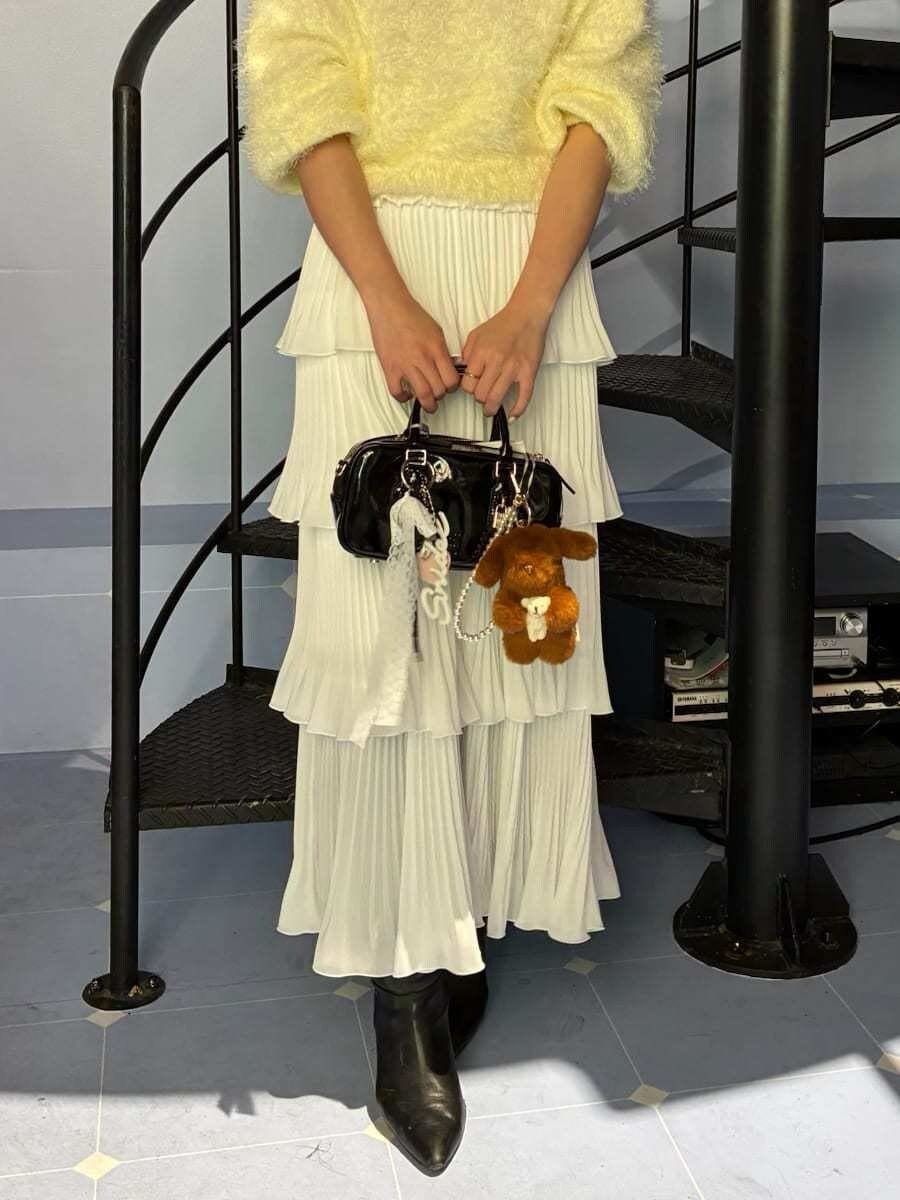 ブラック系のブーツ、ブラック系のボストンバッグ、イエロー系のニット/セーターを着用したレディースの冬コーディネートの5枚目の写真