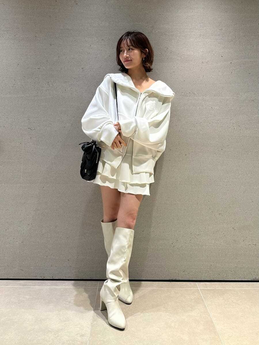 ホワイト系のパーカー、ホワイト系のブーツ、ブラック系のショルダーバッグを着用したレディースの冬コーディネートの3枚目の写真