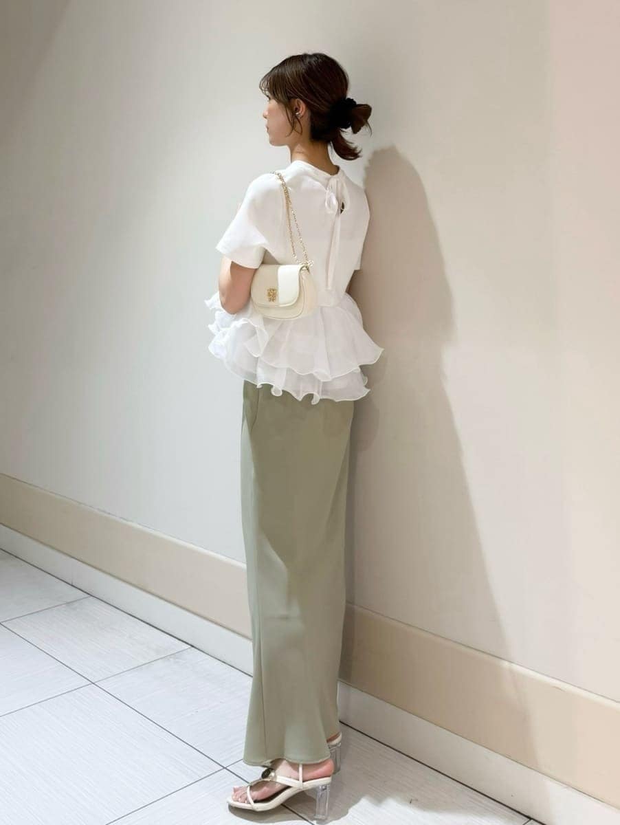 グリーン系のスカート、ホワイト系のTシャツ/カットソー、ホワイト系のショルダーバッグを着用したレディースの春コーディネートの2枚目の写真