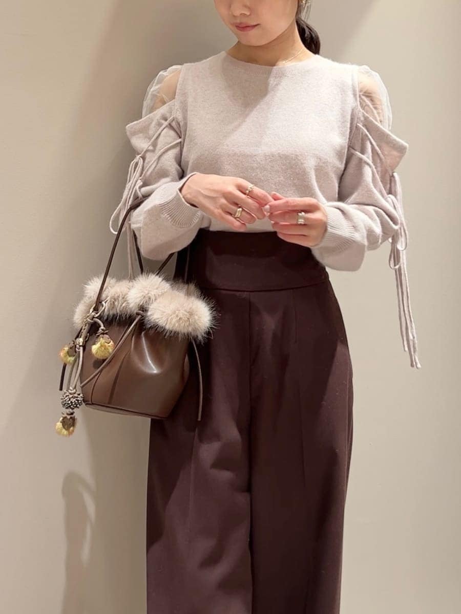 ブラウン系のスラックス、ピンク系のニット/セーター、ブラウン系のハンドバッグを着用したレディースの冬コーディネートの5枚目の写真