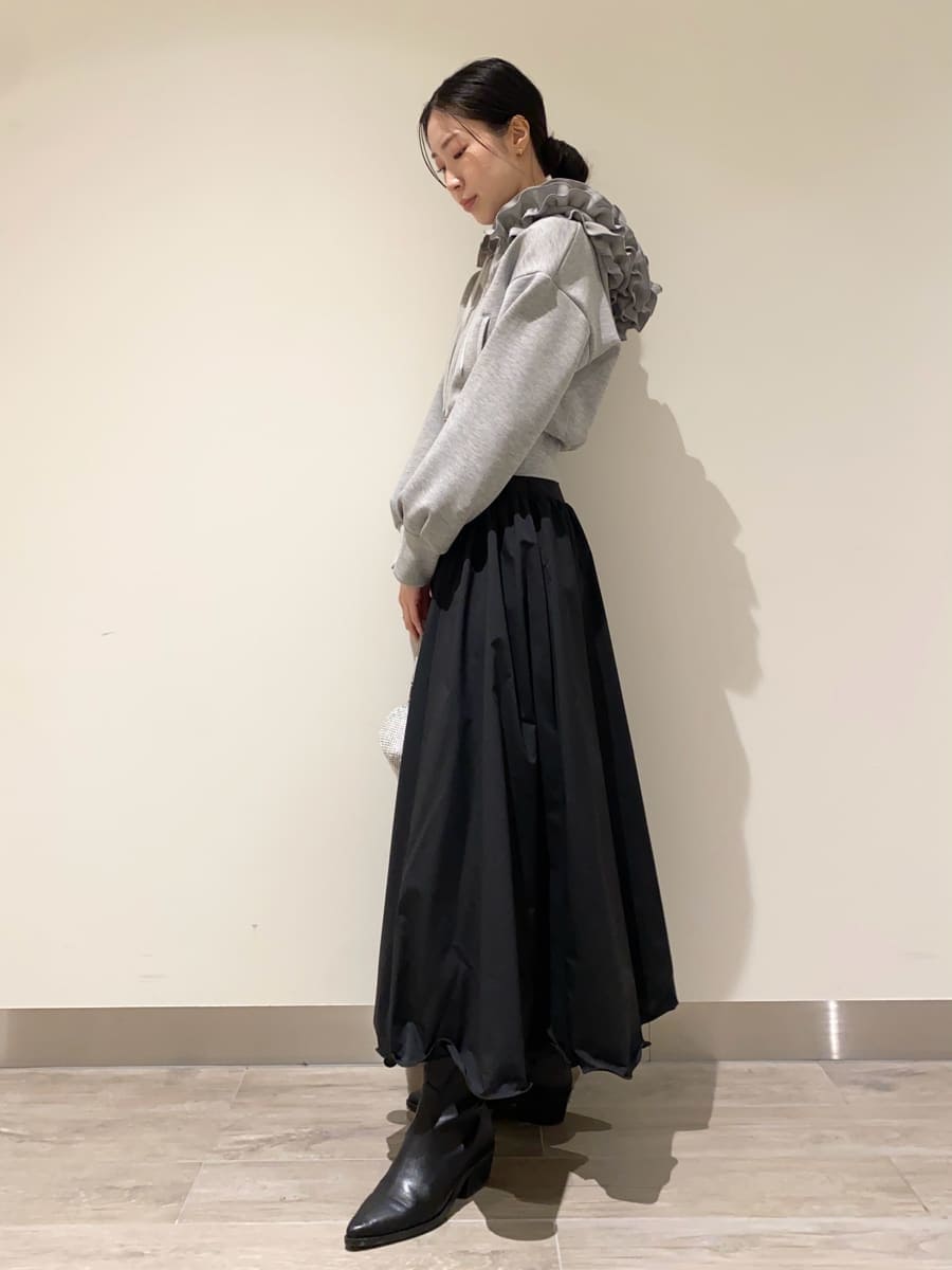 ブラック系のパンプス、グレー系のパーカー、ブラック系のスカートを着用したレディースの冬コーディネートの2枚目の写真