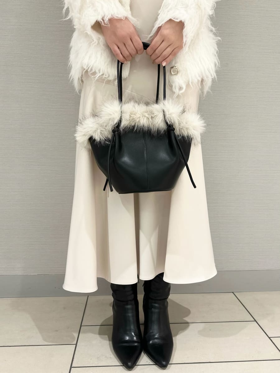 ブラック系のブーツ、ホワイト系のワンピース、ホワイト系のカーディガン/ボレロを着用したレディースの冬コーディネートの4枚目の写真