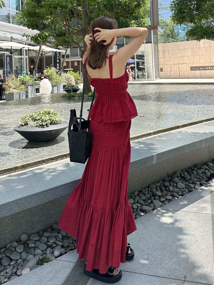 レッド系のスカート、レッド系のシャツ/ブラウス、ゴールド系のピアス（両耳用）を着用したレディースの夏コーディネートの2枚目の写真