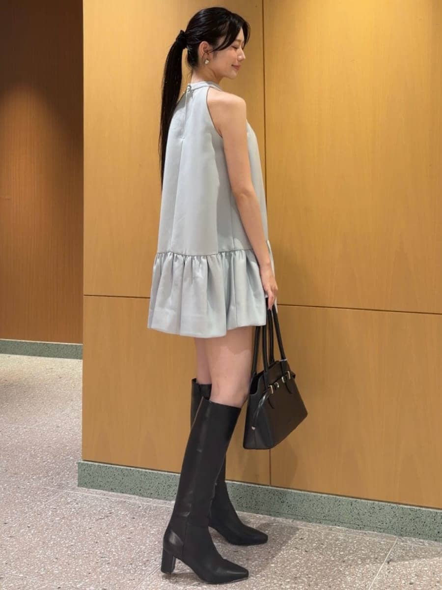 ブルー系のワンピース、ブラック系のブーツ、ブラック系のボストンバッグを着用したレディースの秋コーディネートの4枚目の写真