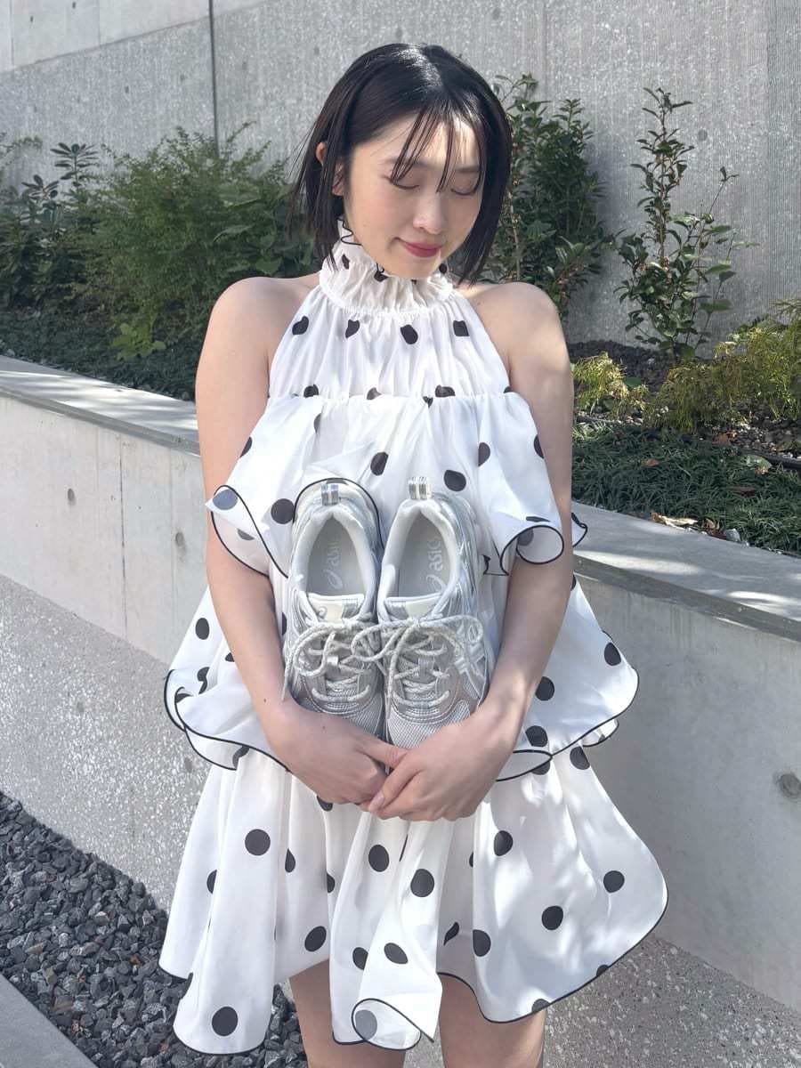 ホワイト系のワンピース、ブラック系のショルダーバッグ、シルバー系のスニーカーを着用したレディースの冬コーディネートの6枚目の写真