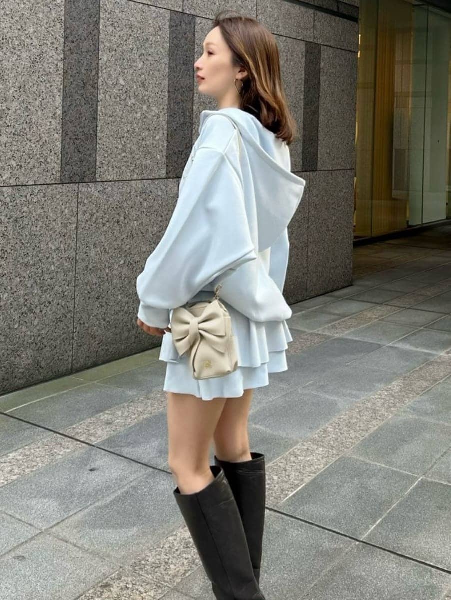 ブルー系のパーカー、ホワイト系のショルダーバッグ、ブルー系のその他パンツを着用したレディースの冬コーディネートの6枚目の写真