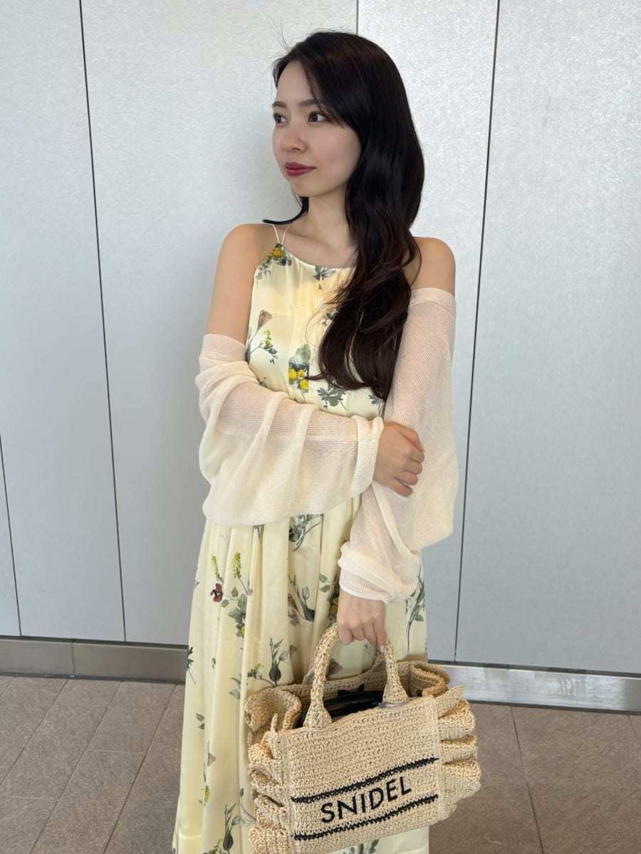 イエロー系のワンピース、ホワイト系のカーディガン/ボレロ、ベージュ系のショルダーバッグを着用したレディースの春コーディネートの6枚目の写真