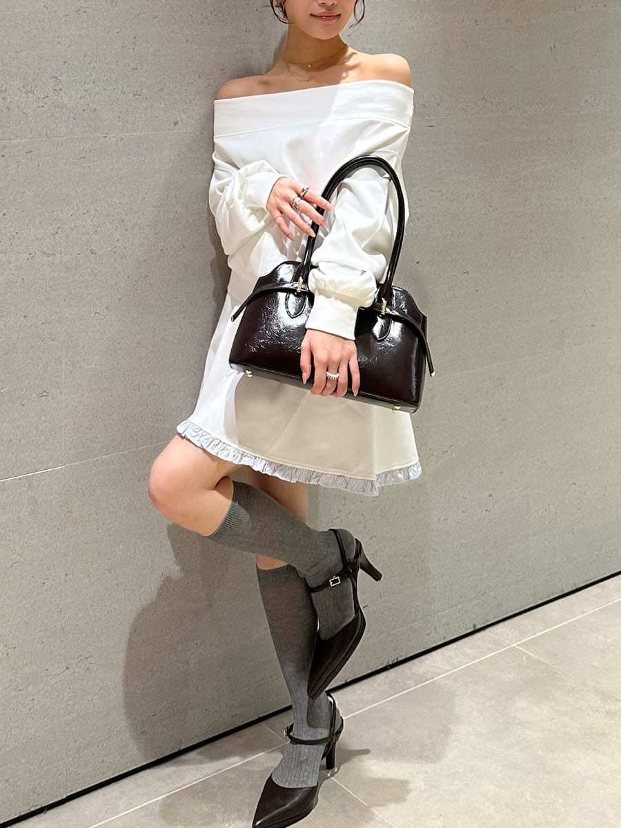 ホワイト系のワンピース、ブラウン系のパンプス、ブラウン系のボストンバッグを着用したレディースの秋コーディネートの2枚目の写真