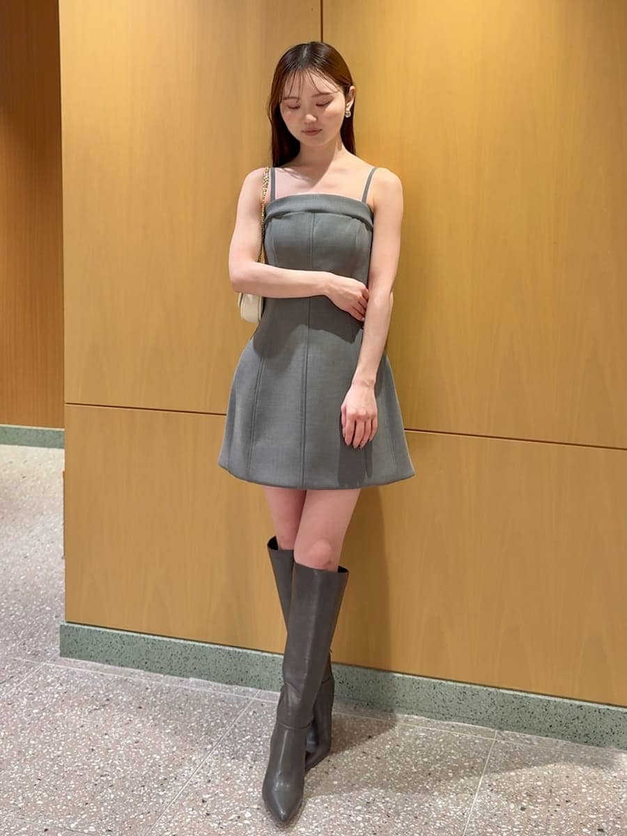 グレー系のブーツ、ホワイト系のトレンチコート、グレー系のワンピースを着用したレディースの冬コーディネートの5枚目の写真