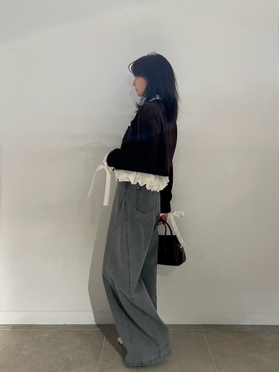 ブラウン系のボストンバッグ、ブラウン系のノーカラージャケット、グレー系のデニムパンツを着用したレディースの夏コーディネートの3枚目の写真