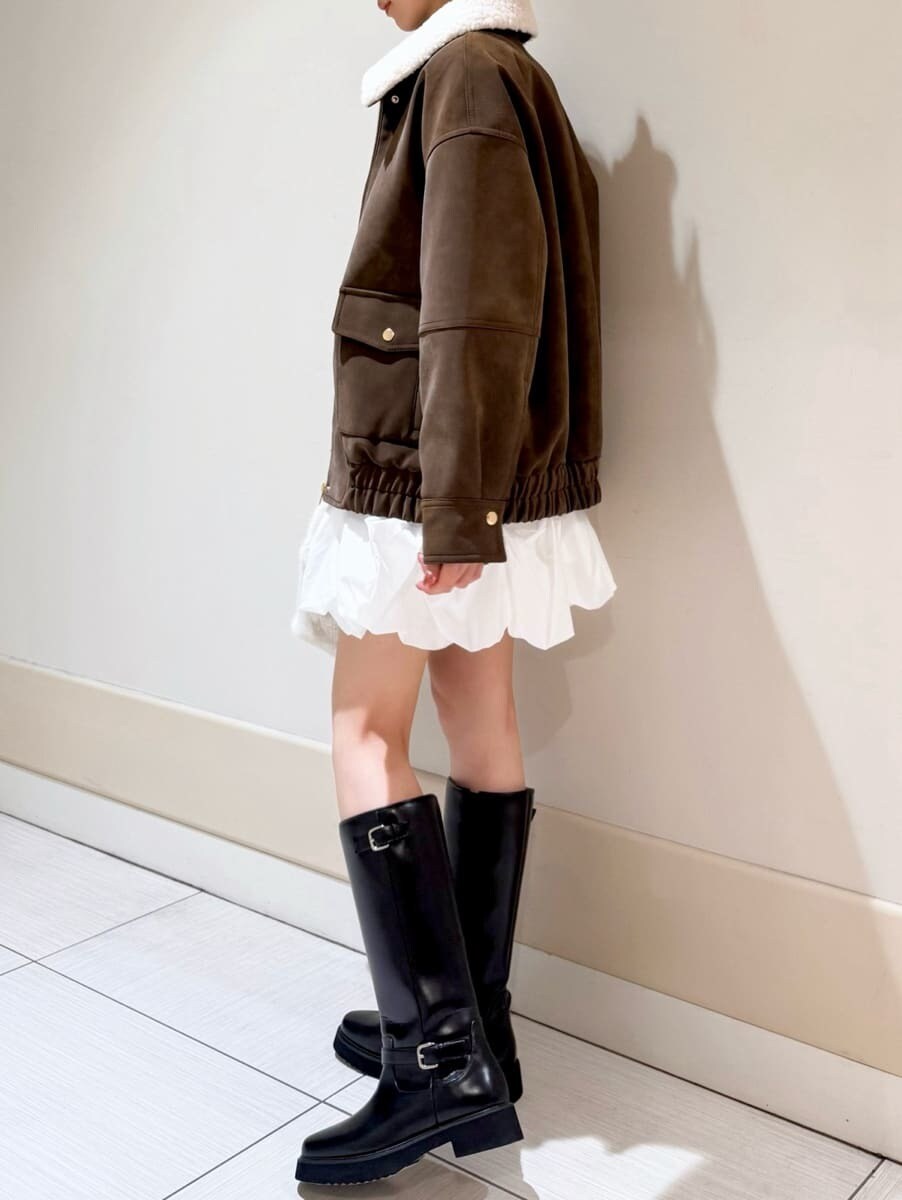ブラック系のブーツ、ブラウン系のブルゾン、ホワイト系のその他パンツを着用したレディースの秋コーディネートの2枚目の写真