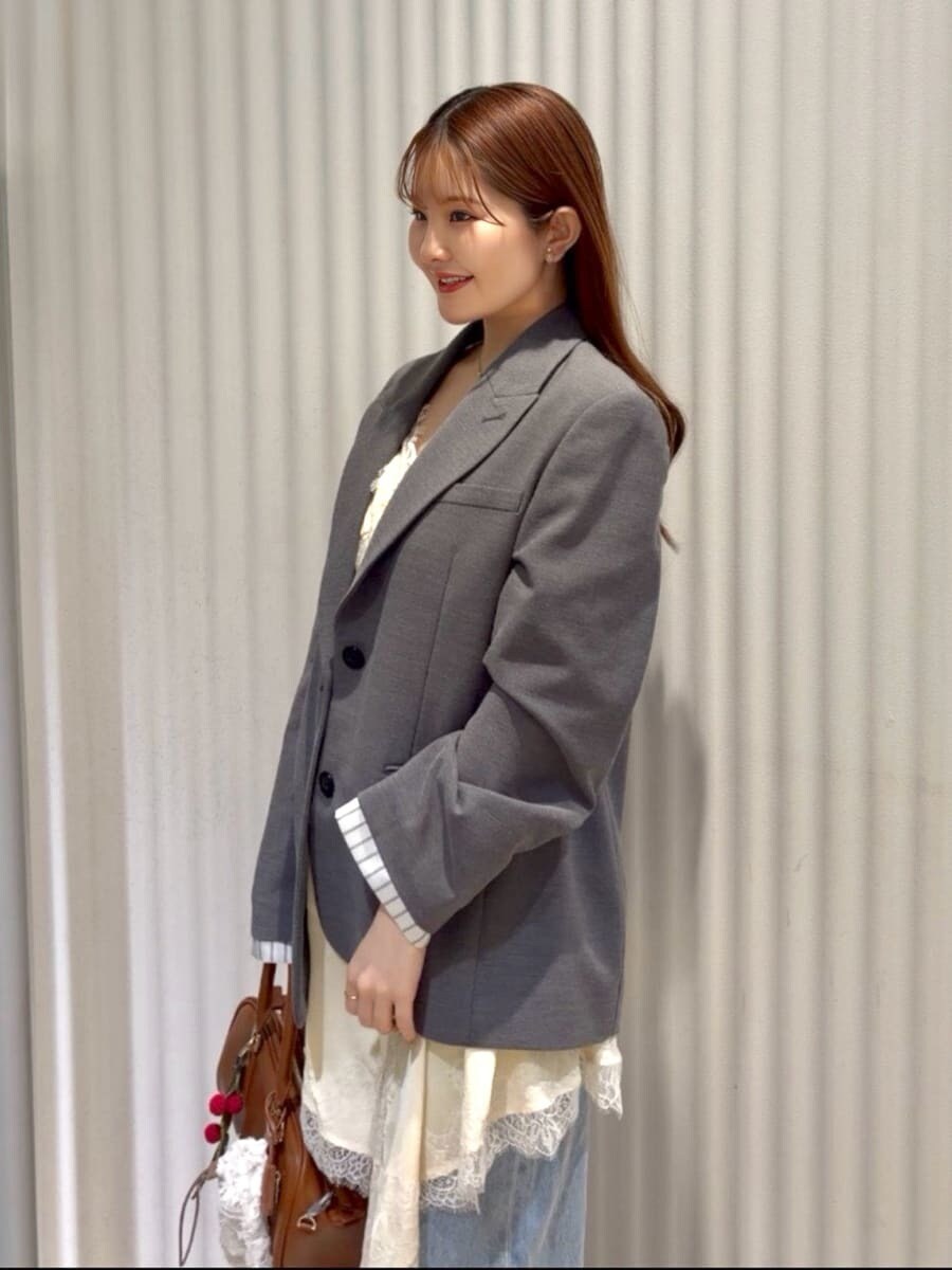 グレー系のテーラードジャケット、ブルー系のデニムパンツ、イエロー系のキャミソールを着用したレディースの春コーディネートの9枚目の写真