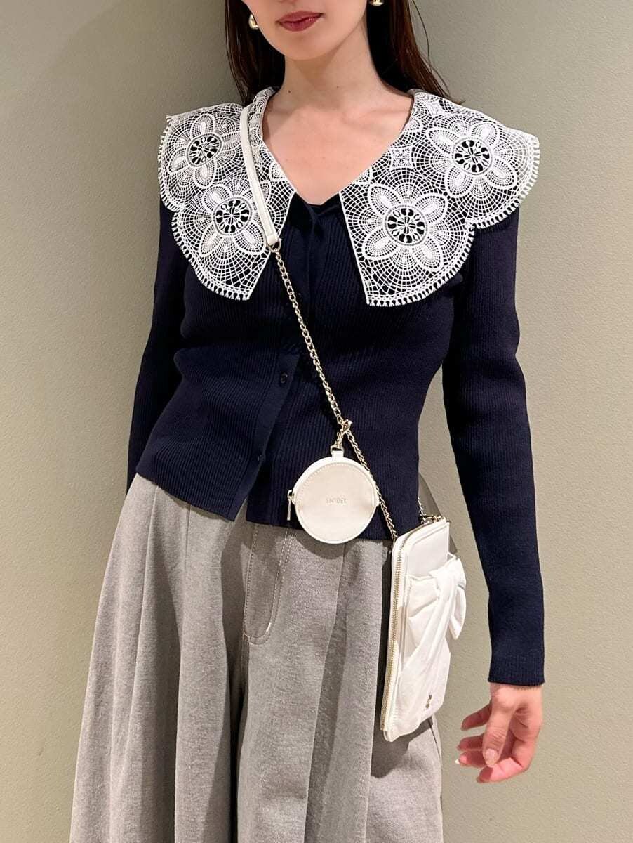 ブルー系のニット/セーター、グレー系のデニムパンツ、ホワイト系のショルダーバッグを着用したレディースの冬コーディネートの2枚目の写真
