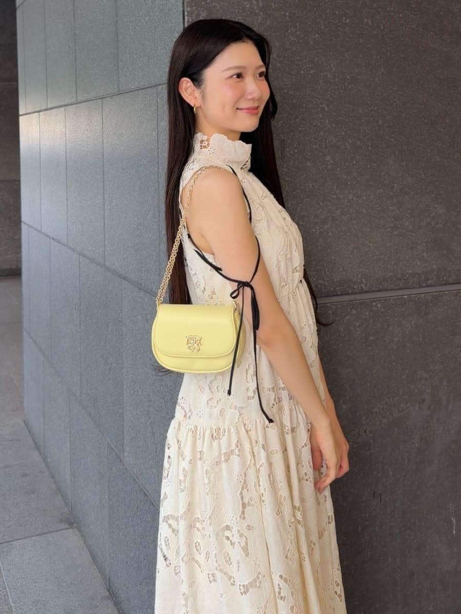 イエロー系のショルダーバッグ、ホワイト系のワンピース、ブラウン系のサンダルを着用したレディースの夏コーディネートの7枚目の写真
