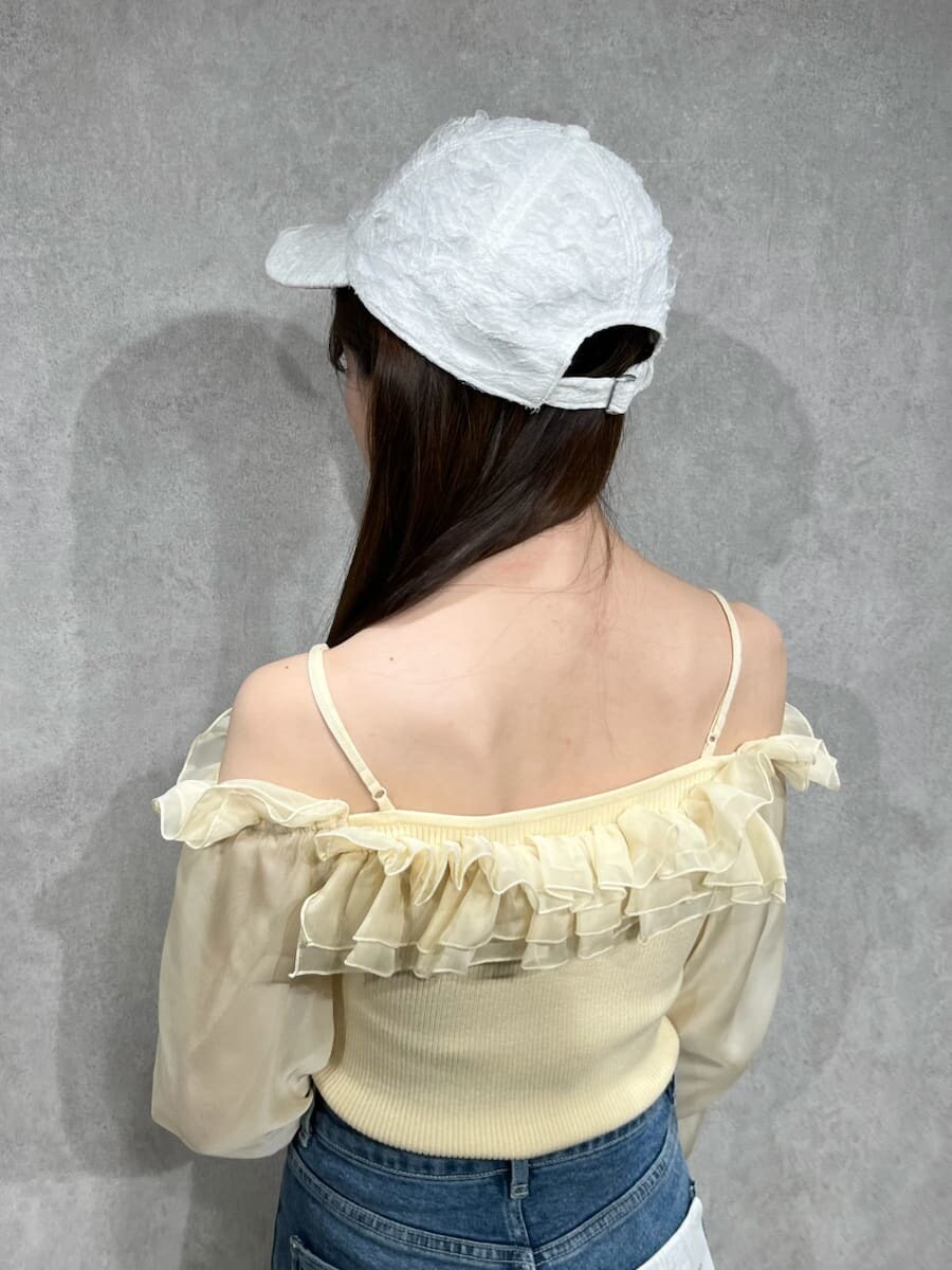 ブルー系のその他パンツ、イエロー系のニット/セーター、ホワイト系のキャップを着用したレディースの冬コーディネートの5枚目の写真