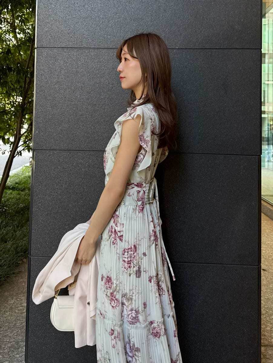 グリーン系のワンピース、ホワイト系のショルダーバッグ、ゴールド系のイヤリングを着用したレディースの春コーディネートの6枚目の写真