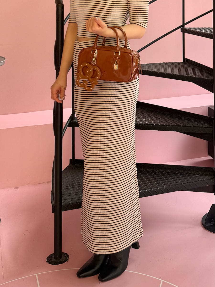 ホワイト系のワンピース、ブラック系のブーツ、ブラウン系のボストンバッグを着用したレディースの秋コーディネートの6枚目の写真