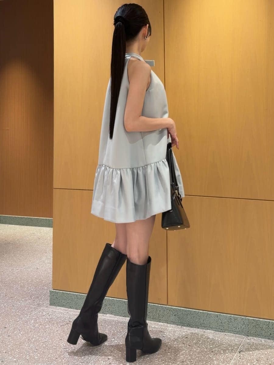 ブルー系のワンピース、ブラック系のブーツ、ブラック系のボストンバッグを着用したレディースの秋コーディネートの6枚目の写真
