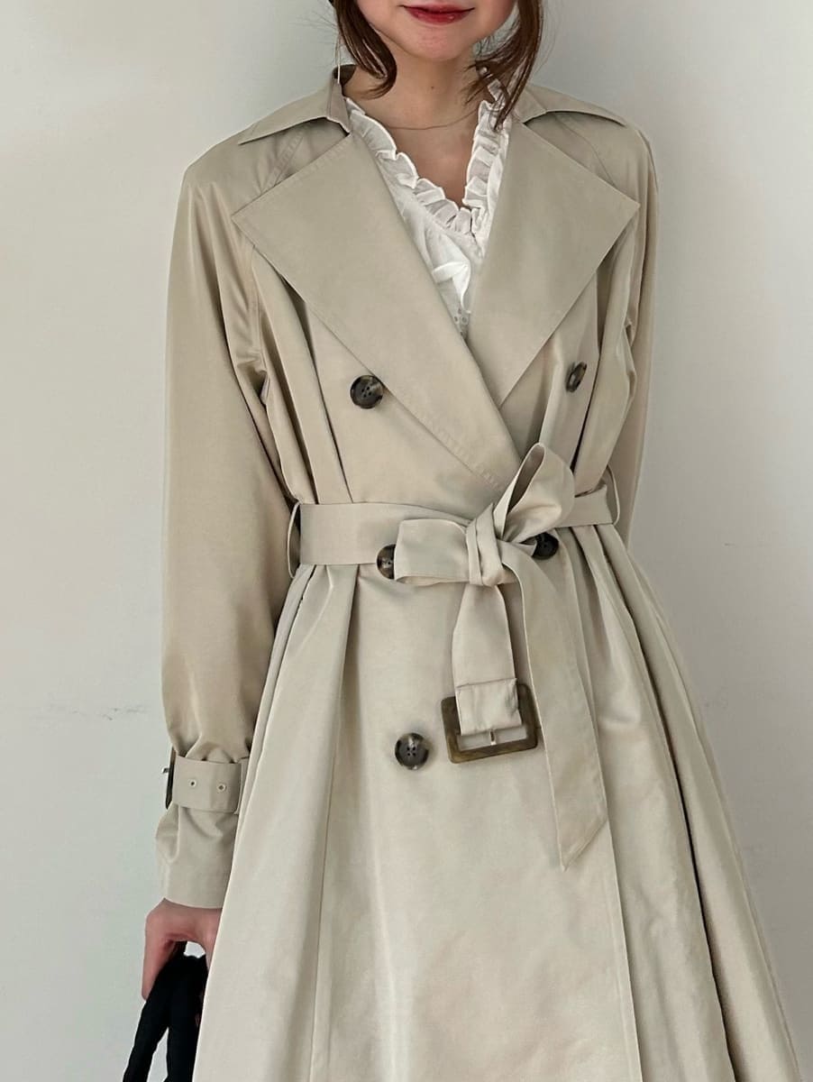 ブラック系のブーツ、ホワイト系のその他トップス、ベージュ系のトレンチコートを着用したレディースの春コーディネートの4枚目の写真