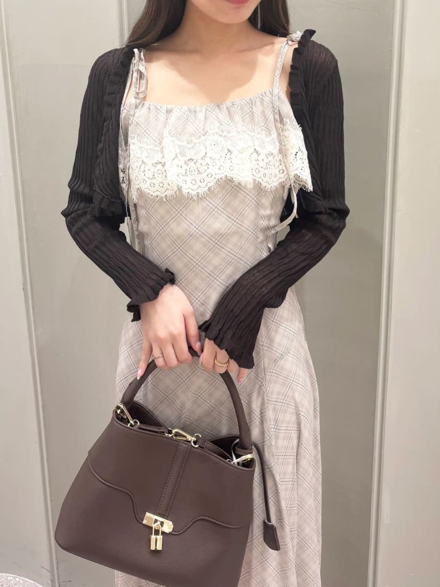 ブラウン系のハンドバッグ、ベージュ系のワンピース、ブラック系のサンダルを着用したレディースの夏コーディネートの4枚目の写真