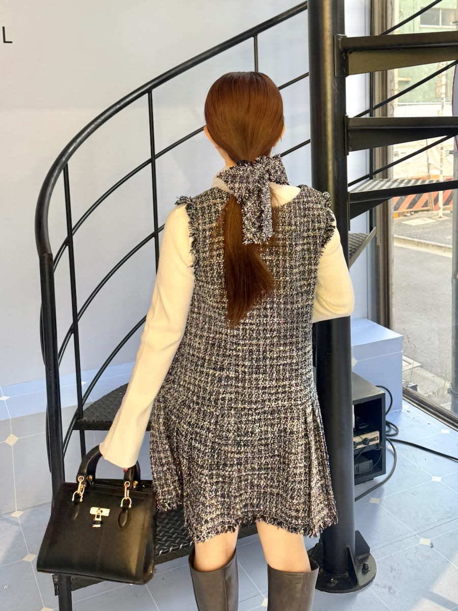 グレー系のブーツ、ブルー系のワンピース、ブラック系のハンドバッグを着用したレディースの冬コーディネートの4枚目の写真