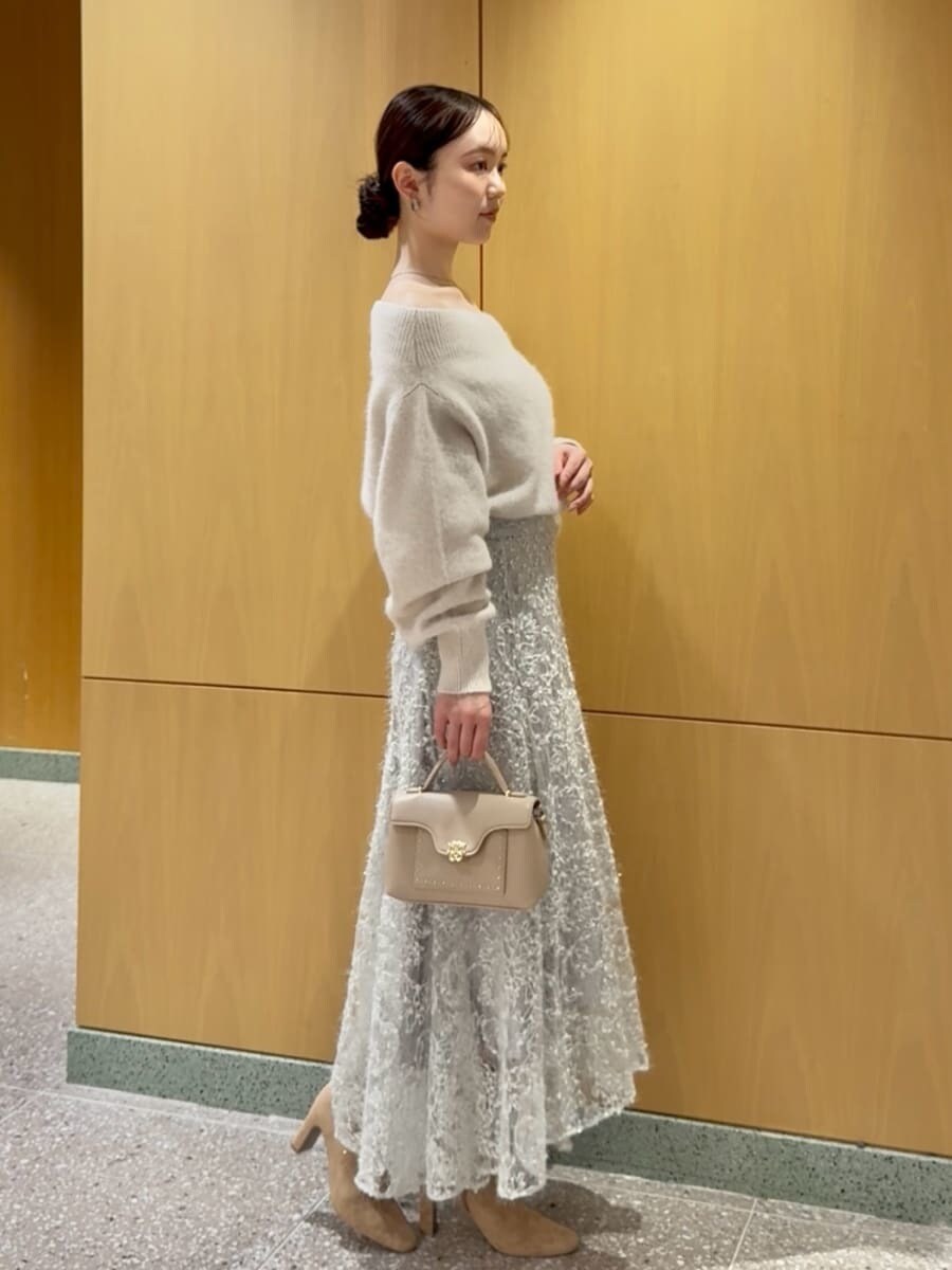 ホワイト系のニット/セーター、グリーン系のスカート、ベージュ系のブーツを着用したレディースの秋コーディネートの2枚目の写真