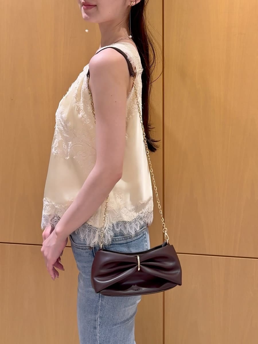 ブルー系のデニムパンツ、イエロー系のキャミソール、その他のイヤリングを着用したレディースの夏コーディネートの6枚目の写真