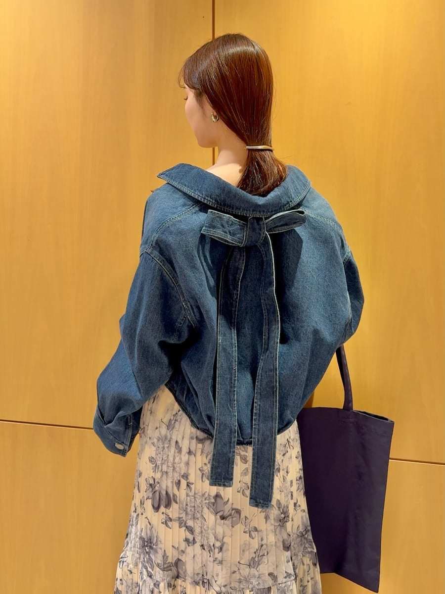 ブルー系のブルゾン、イエロー系のワンピース、ブルー系のトートバッグを着用したレディースの冬コーディネートの7枚目の写真