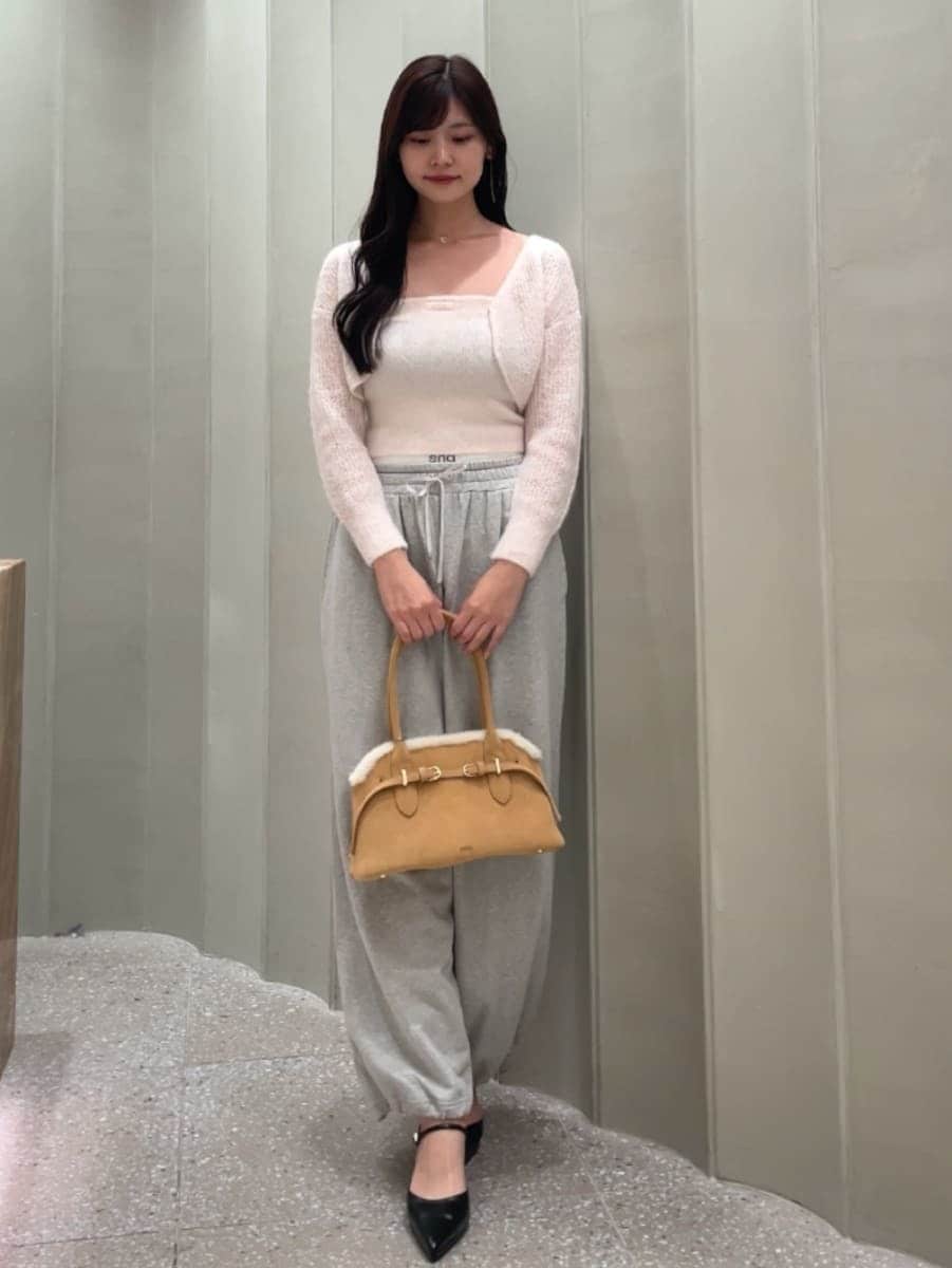 グレー系のその他パンツ、ピンク系のカーディガン/ボレロ、ブラック系のパンプスを着用したレディースの秋コーディネートの3枚目の写真