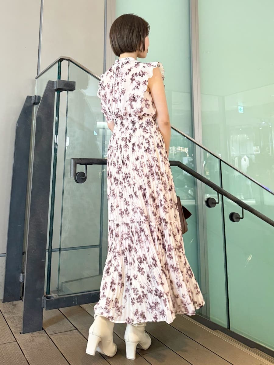 ピンク系のワンピース、ホワイト系のテーラードジャケット、ブラウン系のハンドバッグを着用したレディースの冬コーディネートの4枚目の写真