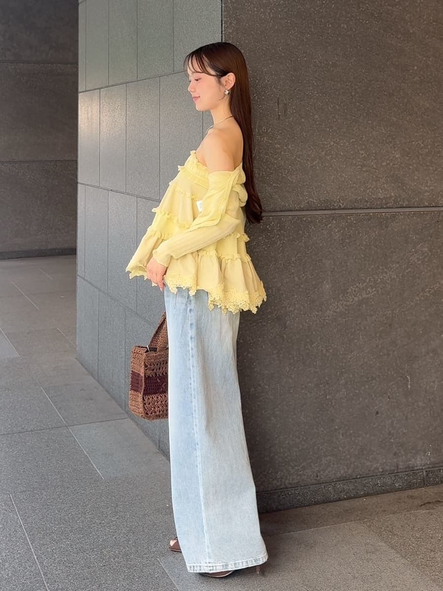 ブルー系のデニムパンツ、イエロー系のニット/セーター、イエロー系のカーディガン/ボレロを着用したレディースの夏コーディネートの2枚目の写真