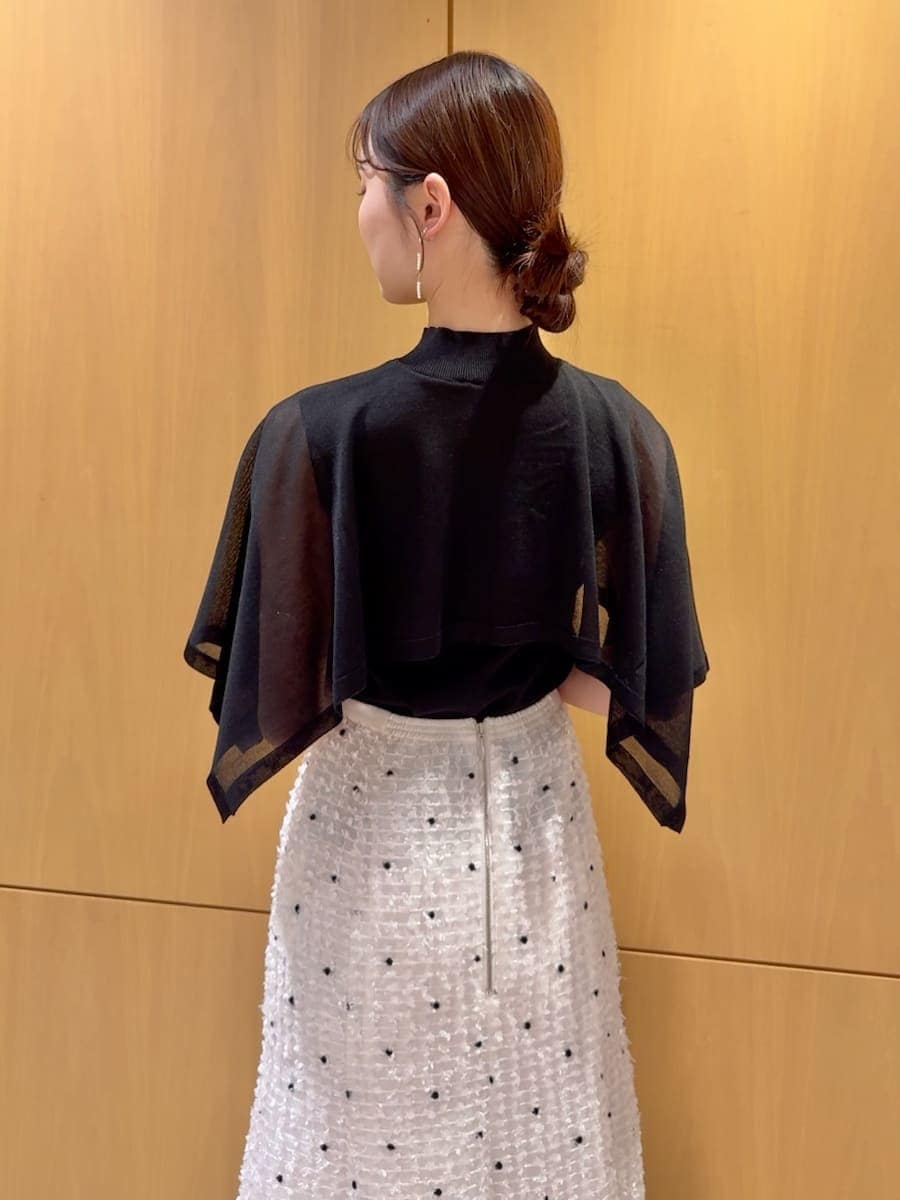 ブラック系のパンプス、ブラック系のハンドバッグ、その他のイヤリングを着用したレディースの春コーディネートの6枚目の写真