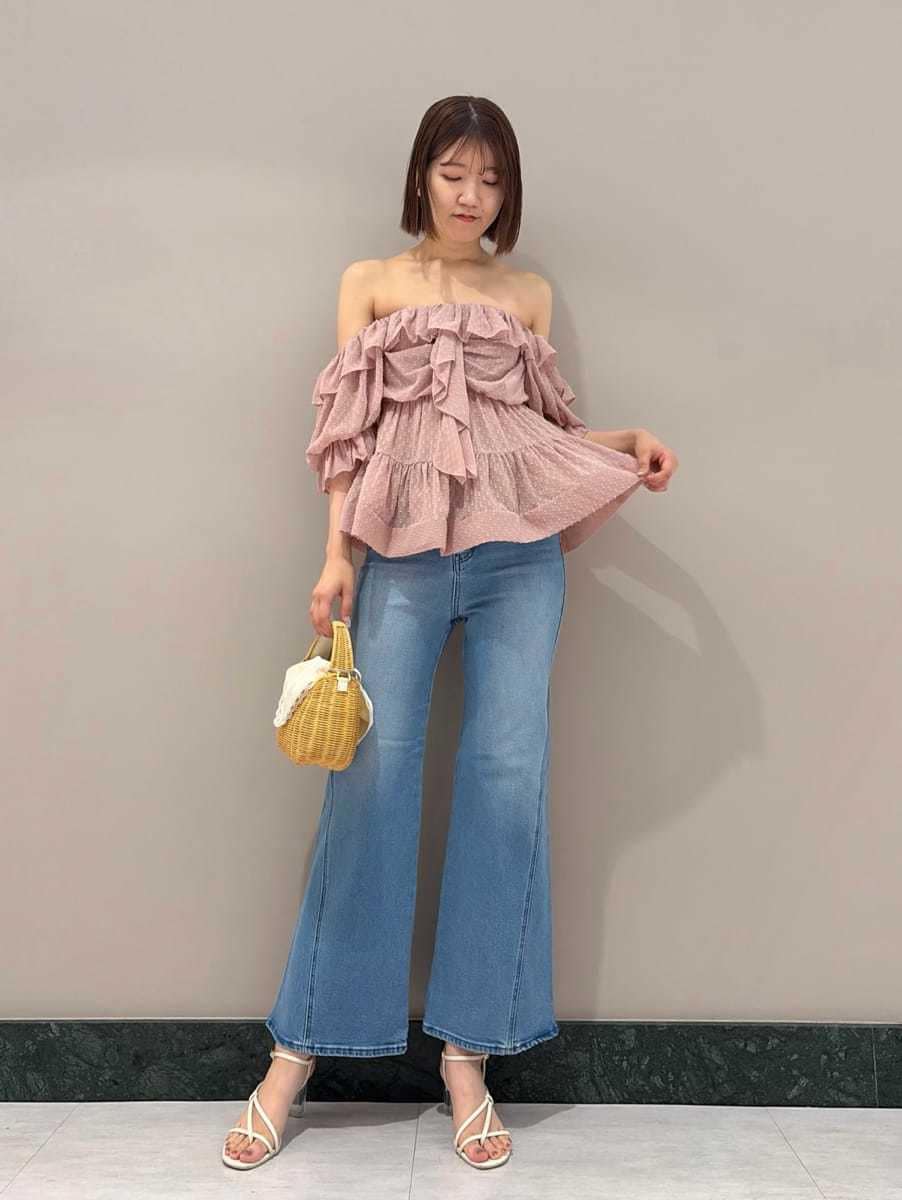 ブルー系のデニムパンツ、ホワイト系のサンダル、ホワイト系のかごバッグを着用したレディースの夏コーディネートの5枚目の写真