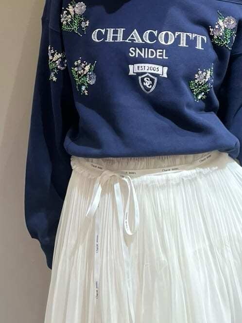 ブルー系のスウェット、ホワイト系のスカート、ホワイト系のショルダーバッグを着用したレディースの秋コーディネートの5枚目の写真