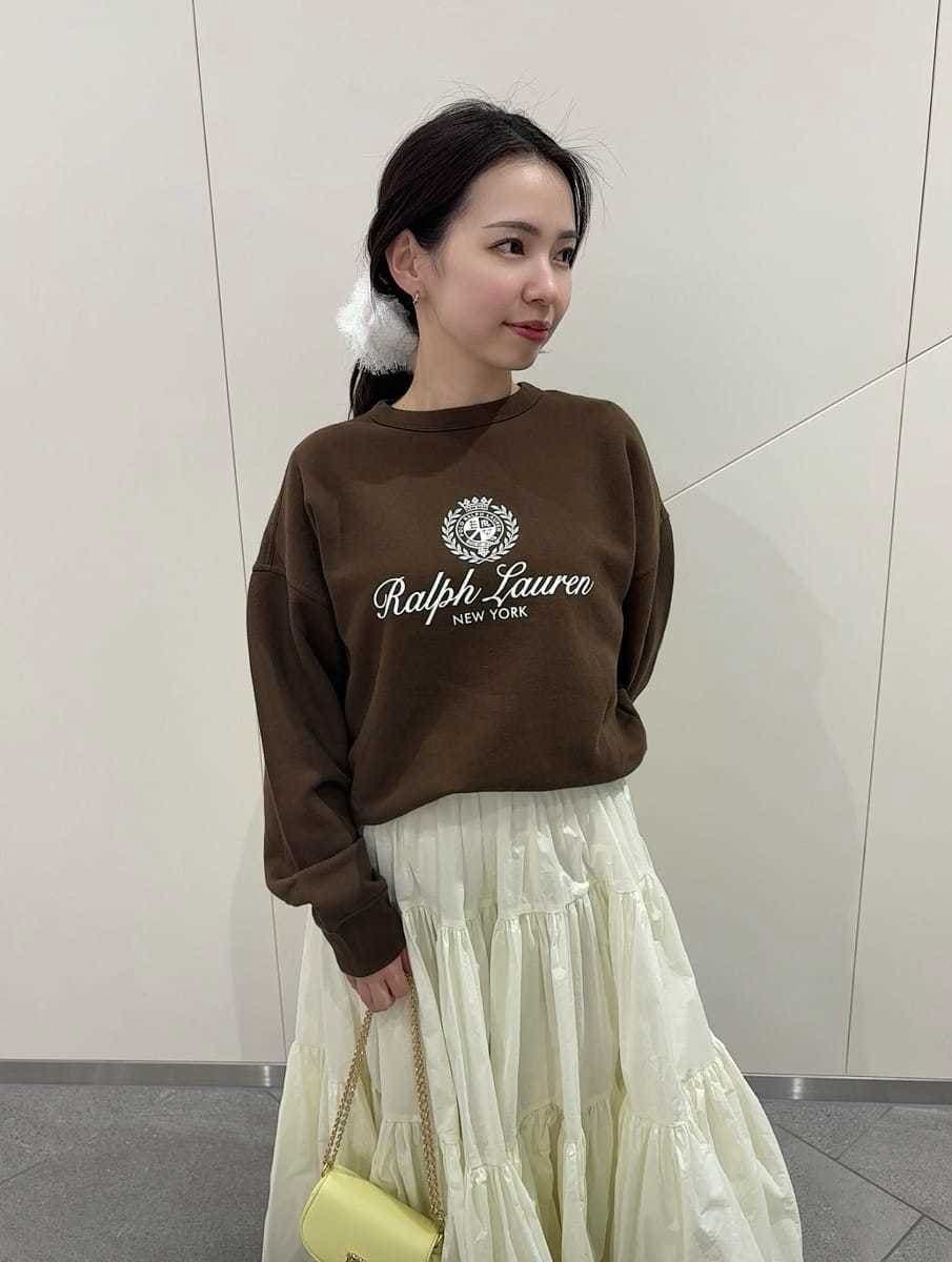 ホワイト系のスカート、ブラウン系のスウェット、イエロー系のショルダーバッグを着用したレディースの春コーディネートの2枚目の写真