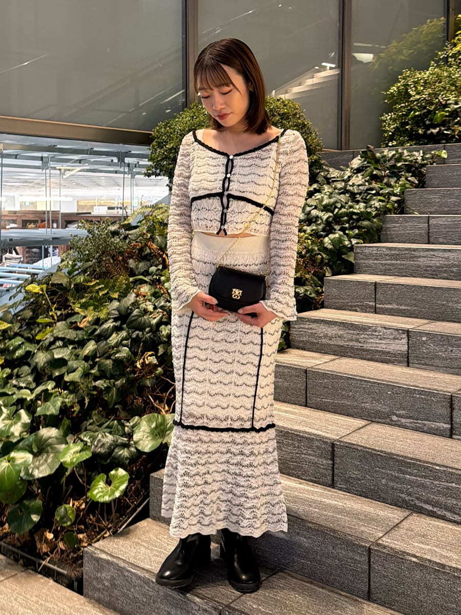 その他のスカート、その他のニット/セーター、ブラック系のショルダーバッグを着用したレディースの春コーディネートの4枚目の写真