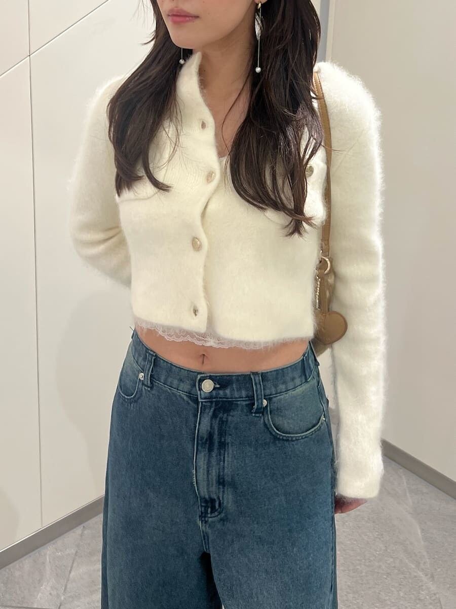 ホワイト系のノーカラージャケット、ブルー系のデニムパンツ、ホワイト系のキャミソールを着用したレディースの秋コーディネートの4枚目の写真