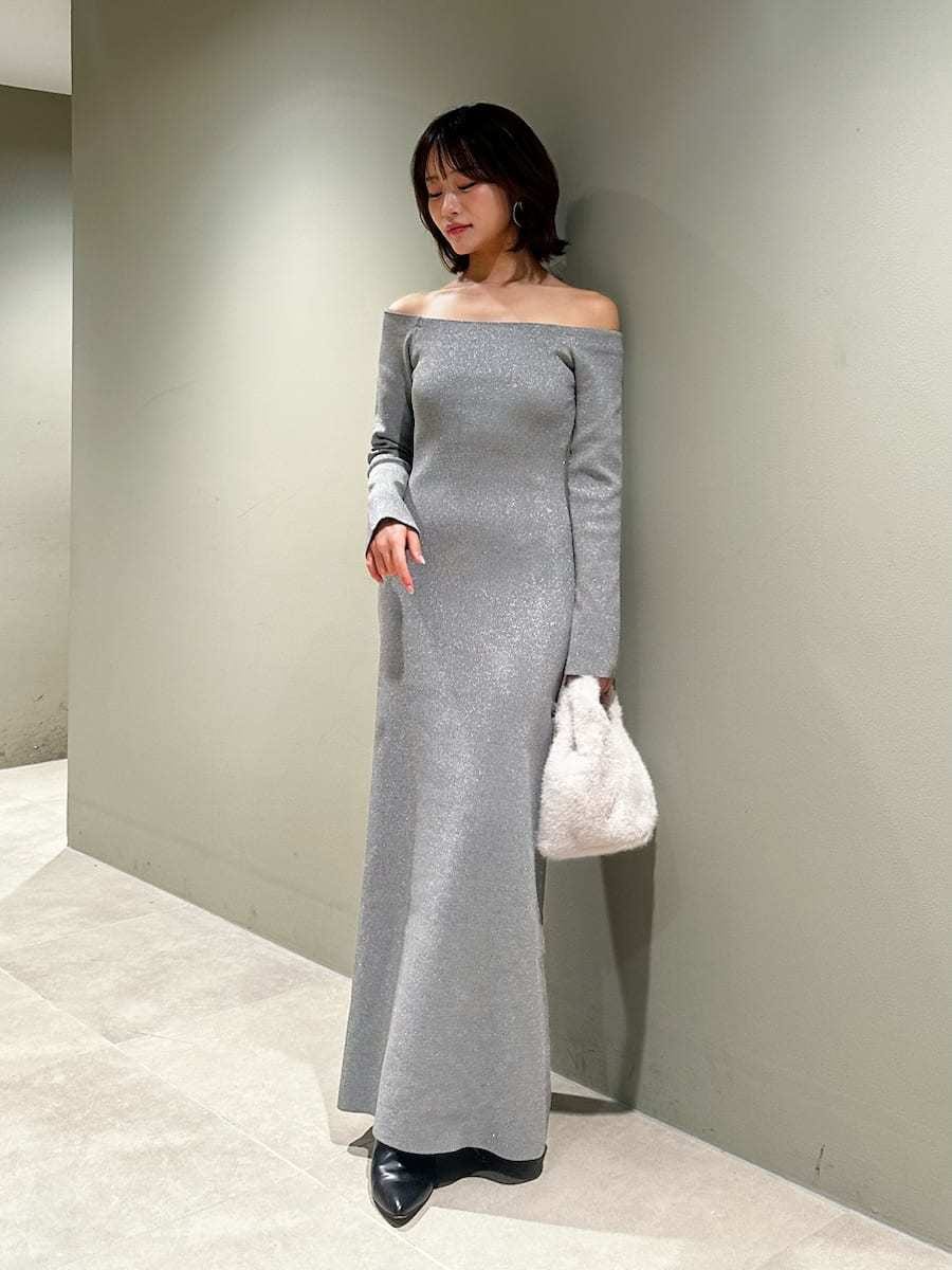 ブラック系のブーツ、シルバー系のワンピース、ホワイト系のハンドバッグを着用したレディースの冬コーディネートの7枚目の写真