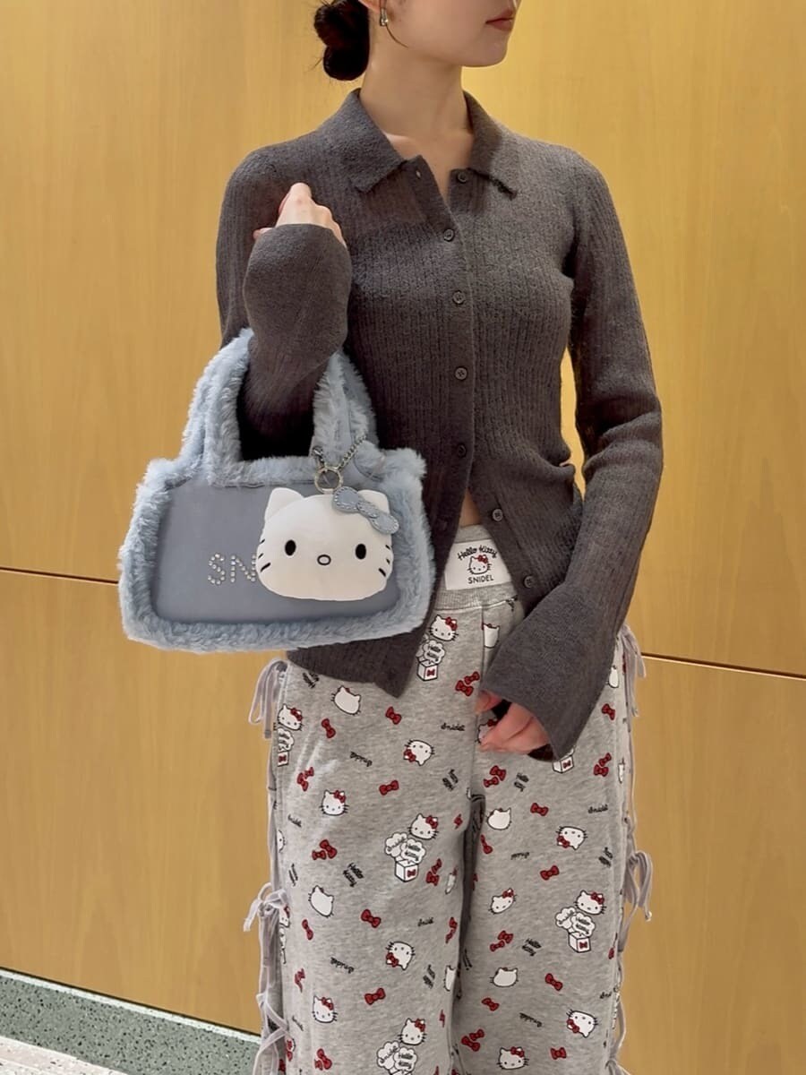 グレー系のニット/セーター、グレー系のその他パンツ、ブルー系のハンドバッグを着用したレディースの秋コーディネートの6枚目の写真