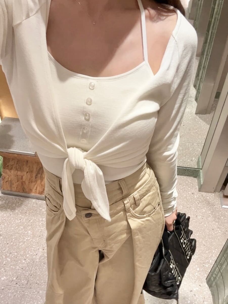 ホワイト系のTシャツ/カットソー、ベージュ系のデニムパンツ、ブラック系のハンドバッグを着用したレディースの秋コーディネートの6枚目の写真