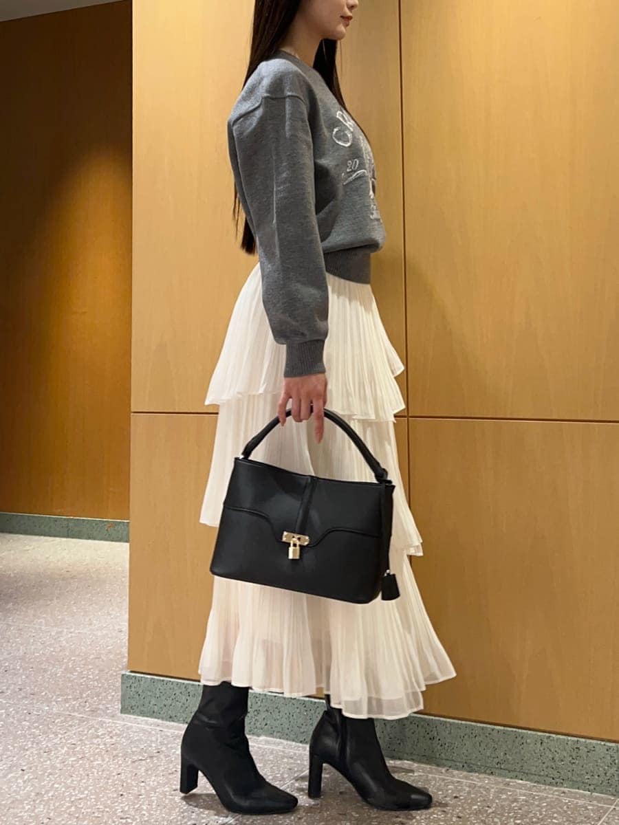 ブラック系のブーツ、ホワイト系のスカート、グレー系のニット/セーターを着用したレディースの秋コーディネートの3枚目の写真