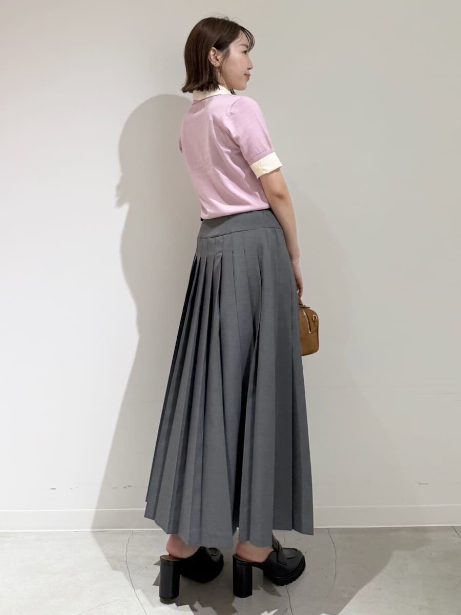 イエロー系のボストンバッグ、ピンク系のニット/セーター、グレー系のスカートを着用したレディースの夏コーディネートの4枚目の写真