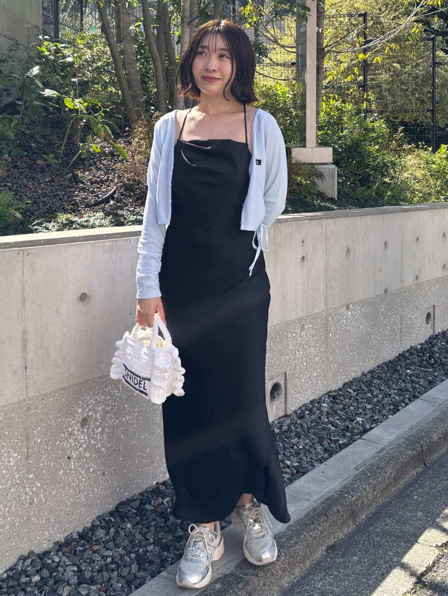シルバー系のスニーカー、ブラック系のワンピースを着用したレディースの春コーディネートの3枚目の写真
